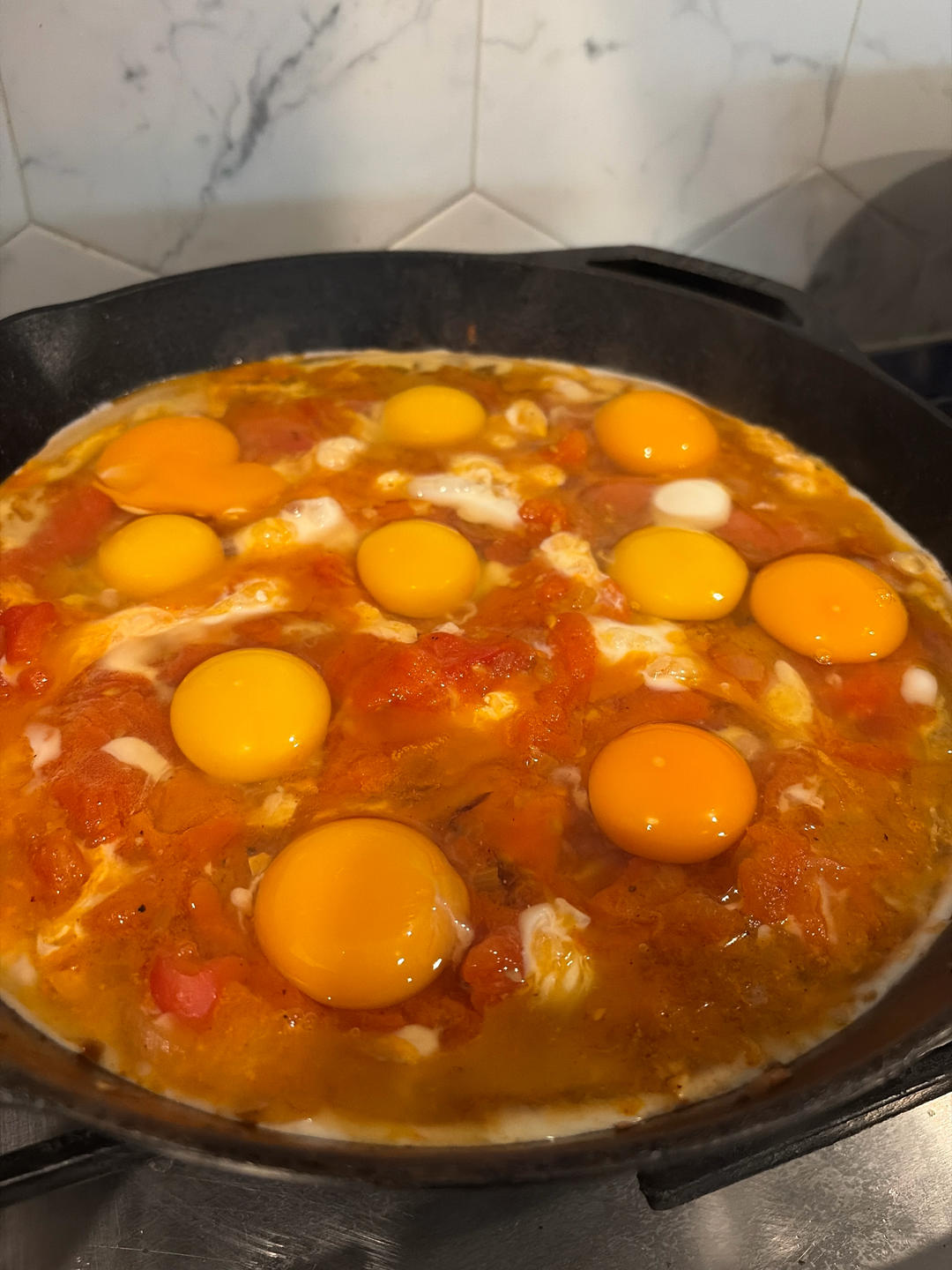 Crack eggs into wells in the sauce