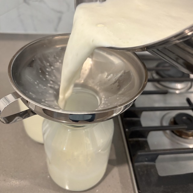 Pouring the half-and-half into a glass jar