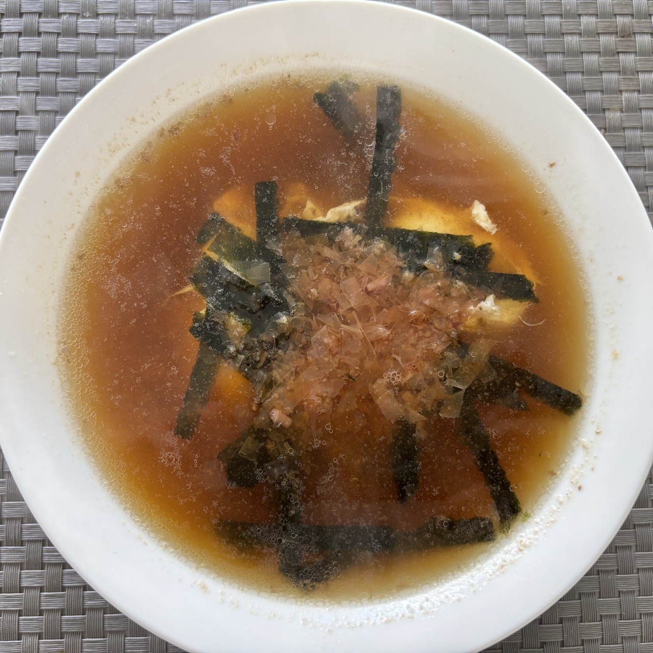 Eggs poached in bone broth with bonito flakes and dried seaweed